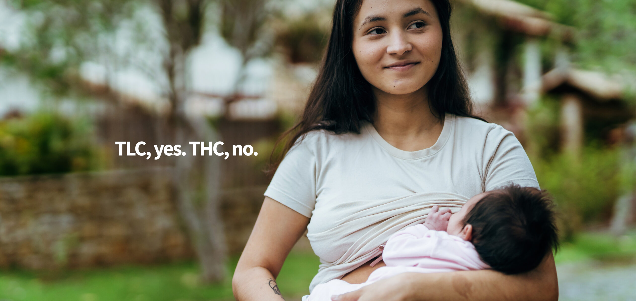 Mother with baby on her lap in the backyard